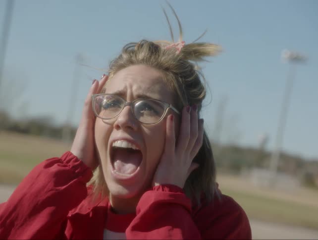 Girl puts hands on side of face and screams