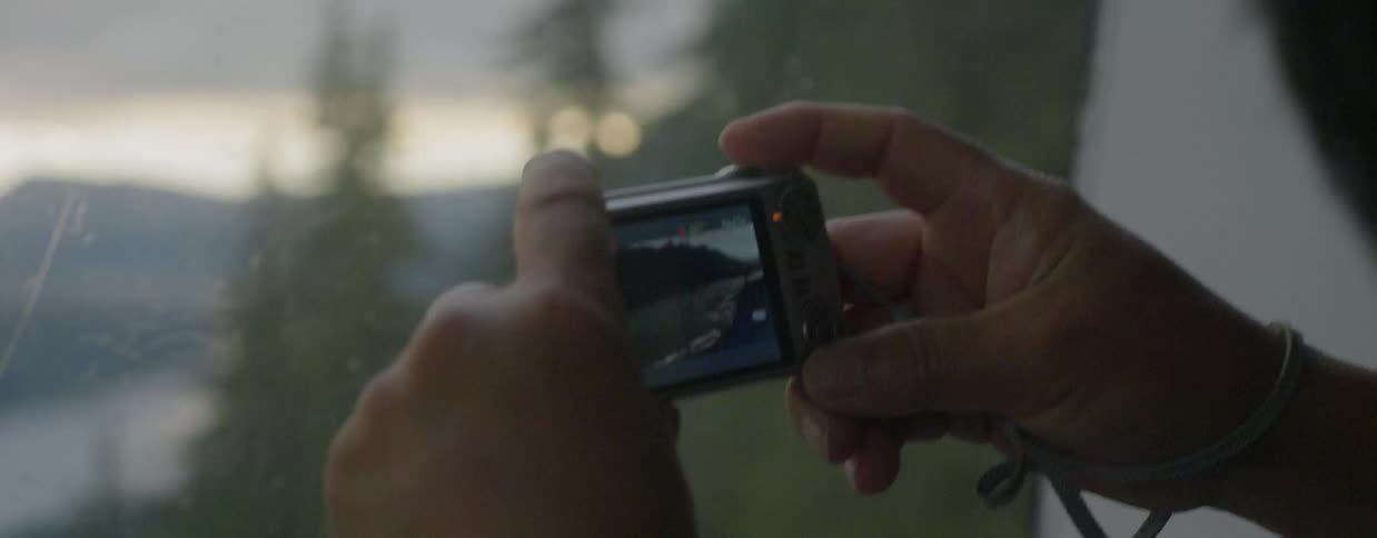 A person riding in a gondola is taking photos of the landscape