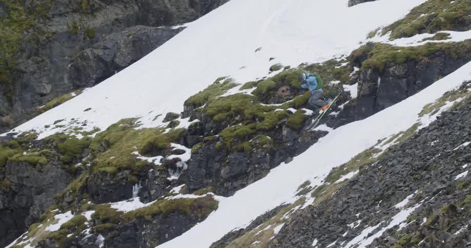 A skier jumps off a rocky mountainside