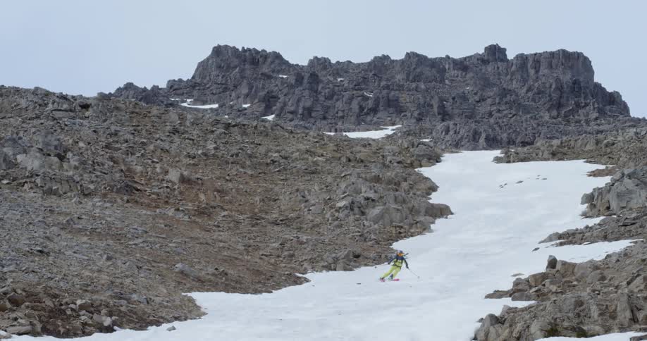 Woman skiing down a steep snow covered mountain