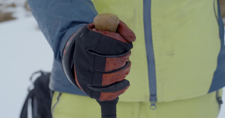 Person grasps the handle on ski pole outside in the snow