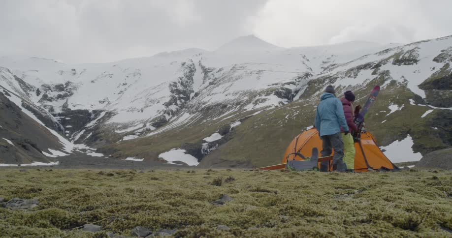 A couple take off their backpacks and stretch when they reach their tent