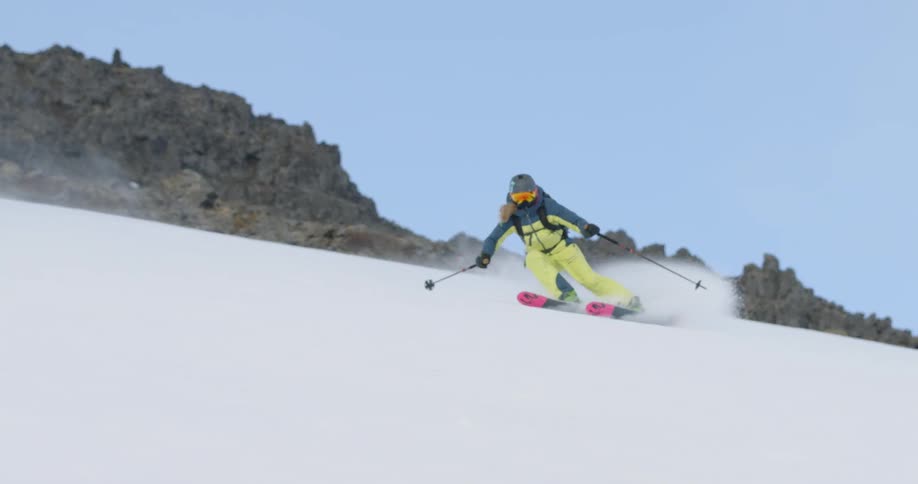 A skier glides down a snowy slope on vacation
