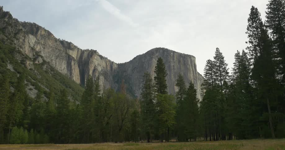 Large mountain with trees in front on a cloudy day