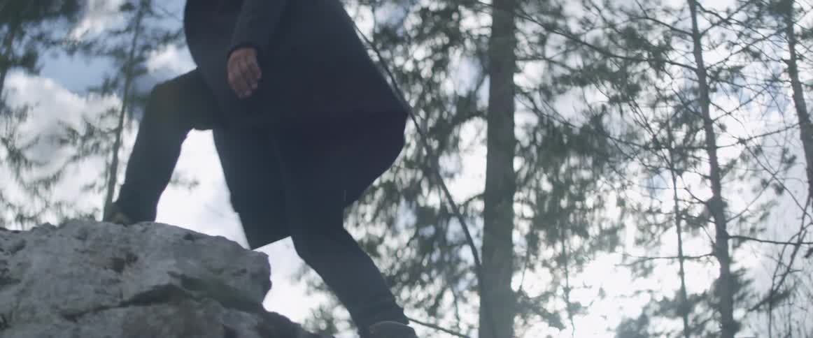 A man climbs up a rocky  hillside