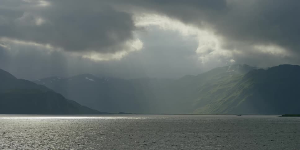 A bay surrounded by mountains on a cloudy day