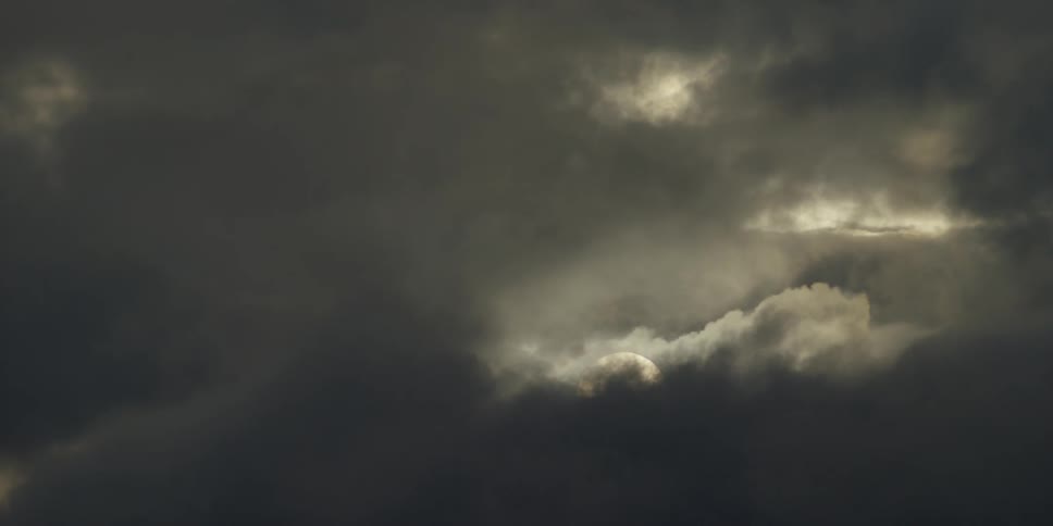Storm clouds move to cover the sun