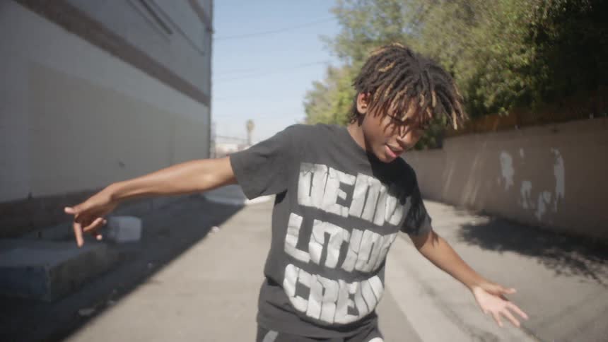 Boy dances in an alleyway