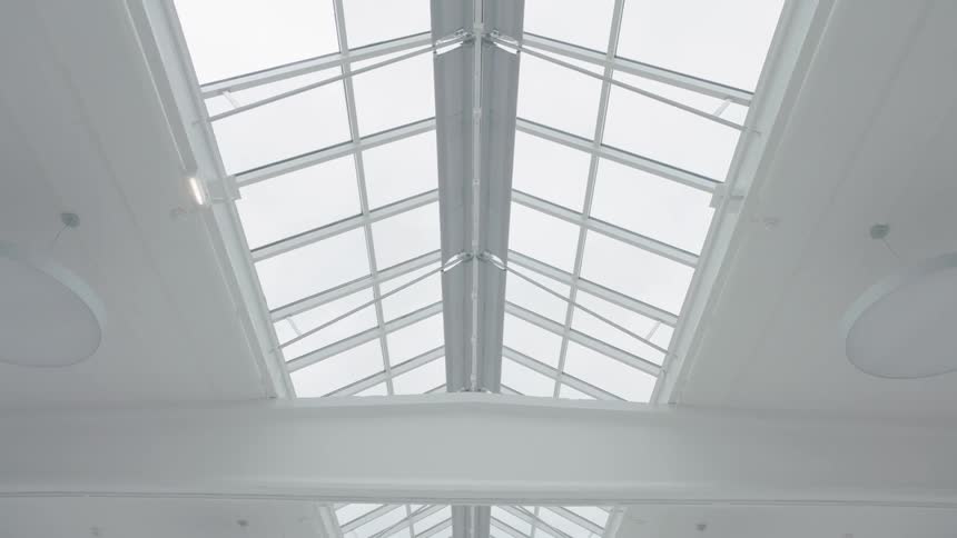 A large white room with a big skylight above on a cloudy day