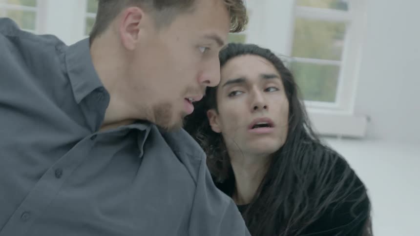 Man and woman dance together in a white room