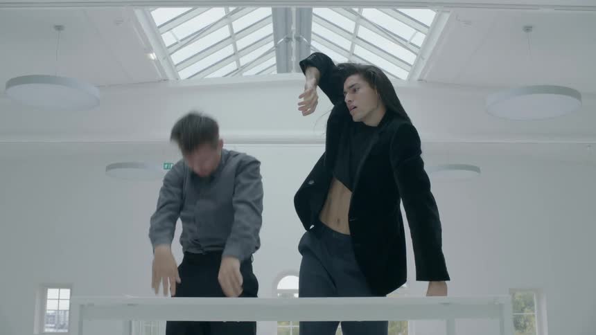 Man and woman dance together in a white room