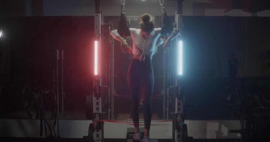 A woman is dangling on gym equipment