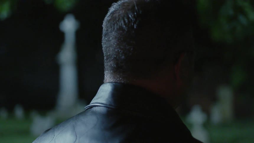 A man is standing in the graveyard at night