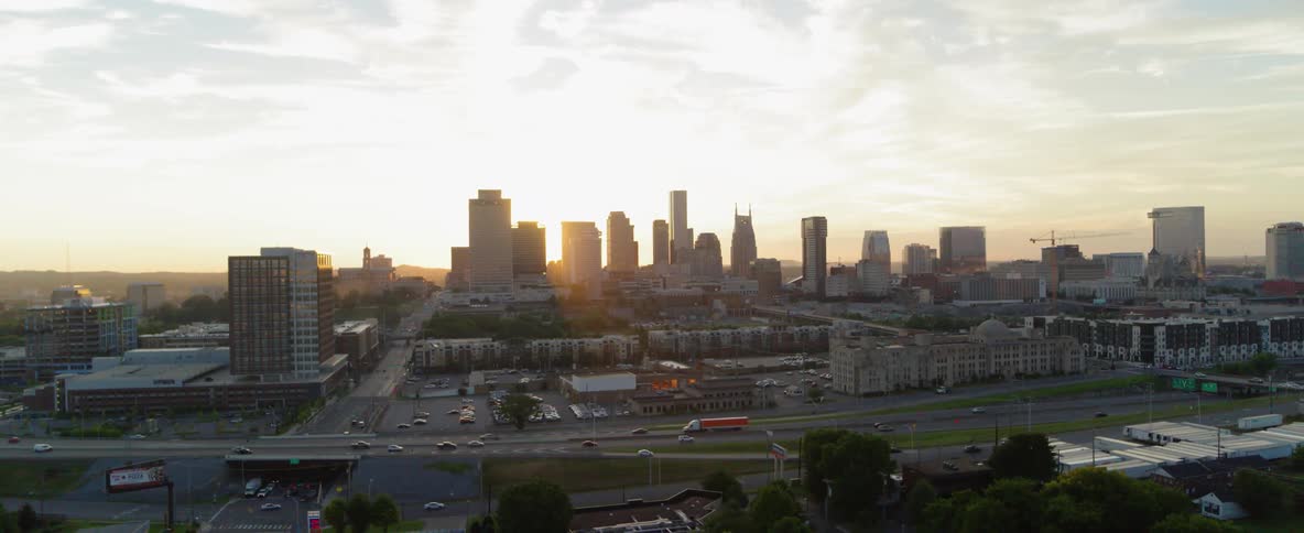 The sun is setting behind the city buildings