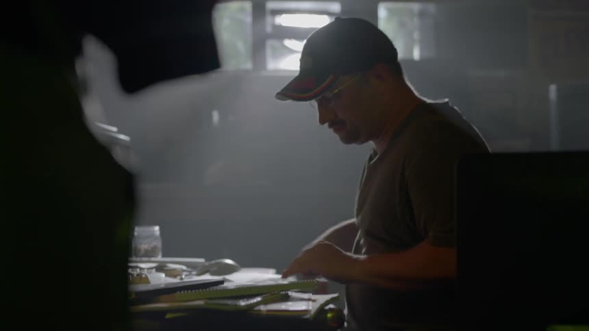 A man tears a sheet of newspaper saving part and tossing the other