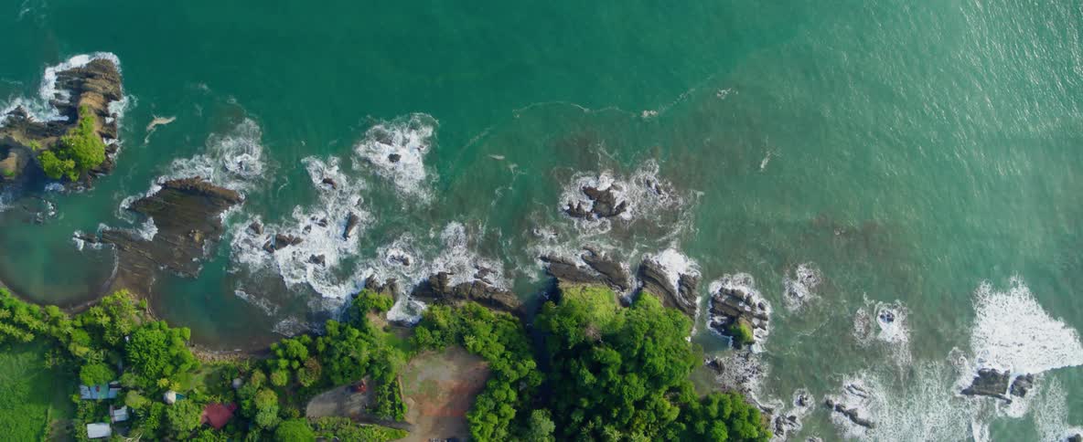 Ocean waves splash over rocks to shore