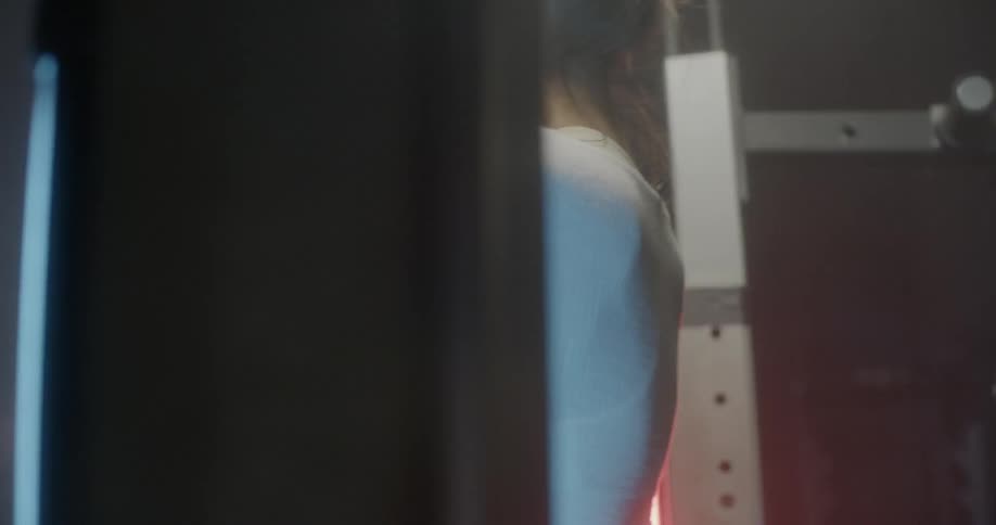 A woman is using her arms to pull herself up in the gym