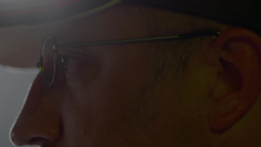 A man wearing glasses looks around