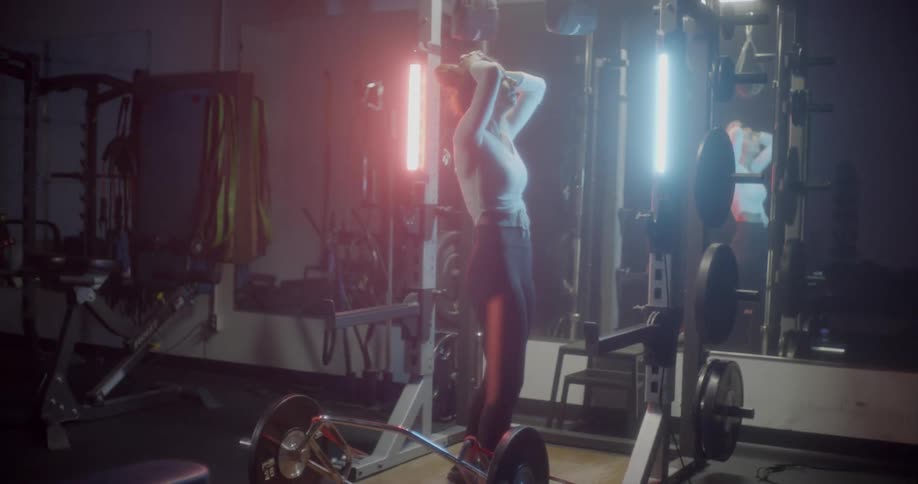 A woman lifts weights in a gym