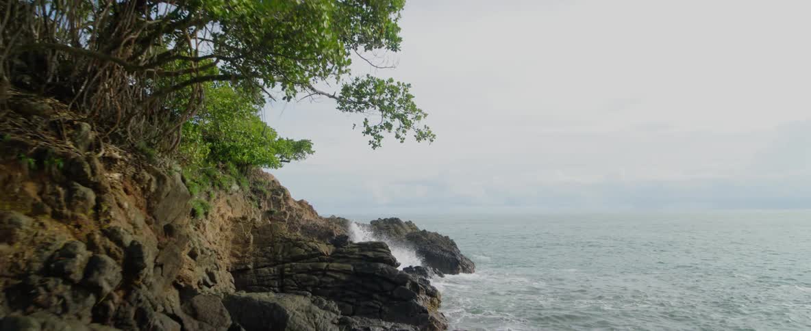 A quiet and calm ocean next to a rocky island