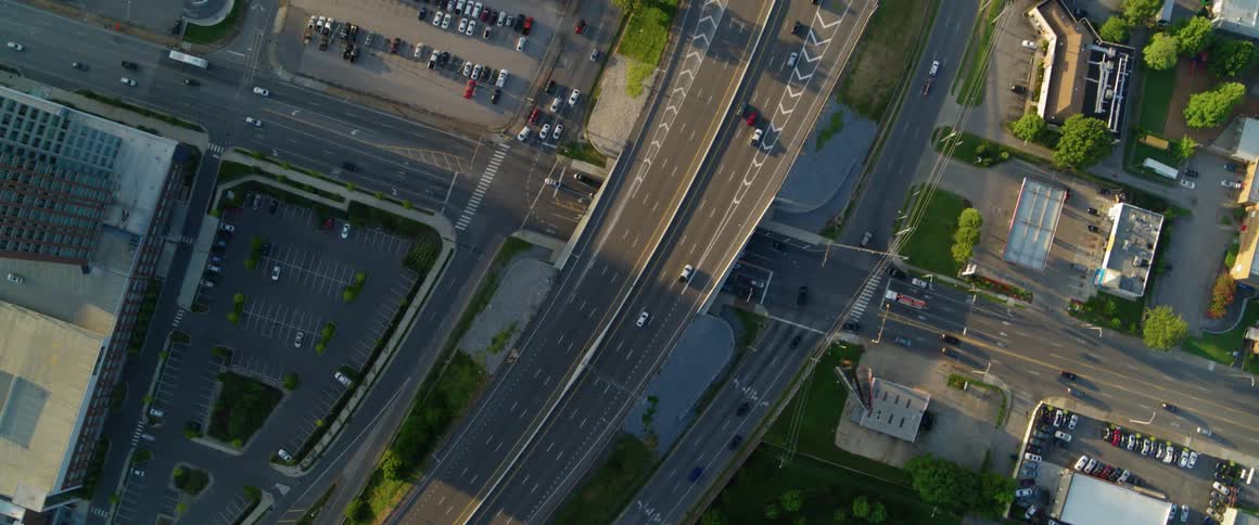 Traffic is flowing on a freeway in an urban area at dawn