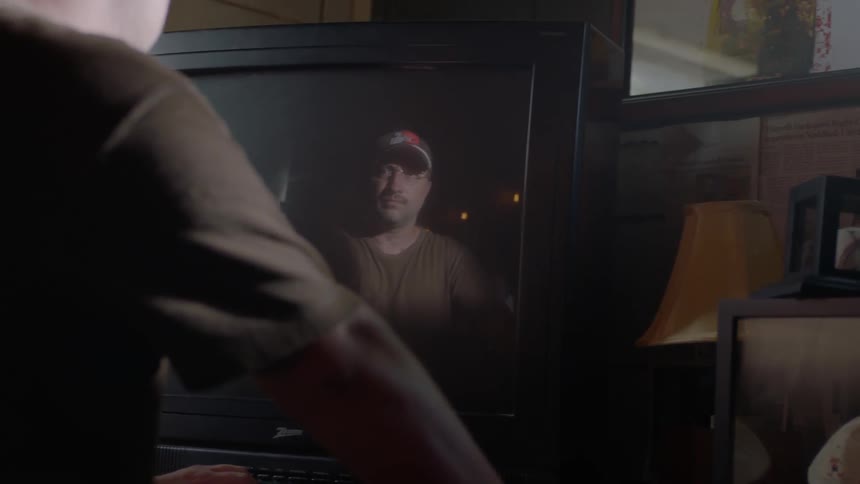 A man looks at his reflecting in the television