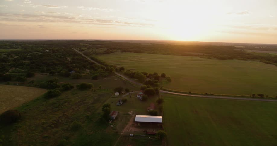 The farm has long green fields all around it