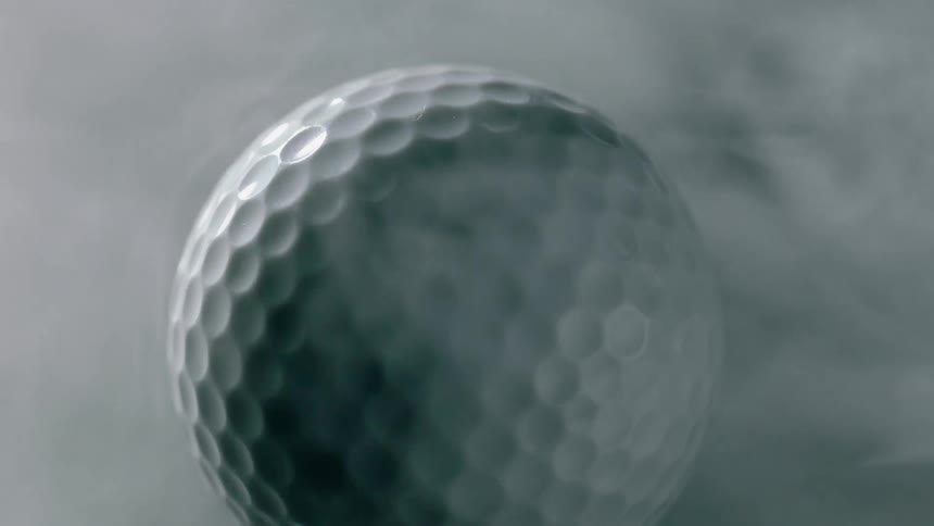 Fog is drifting over a golf ball as it rotates
