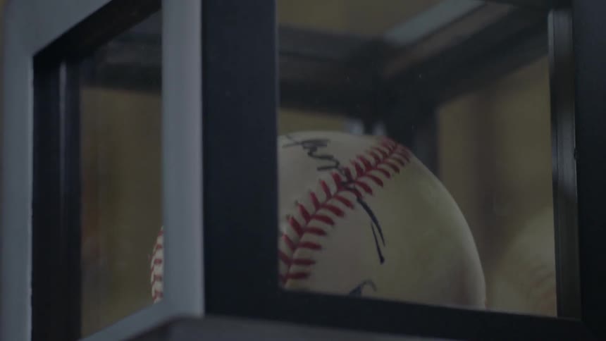 A signed baseball is in a display case
