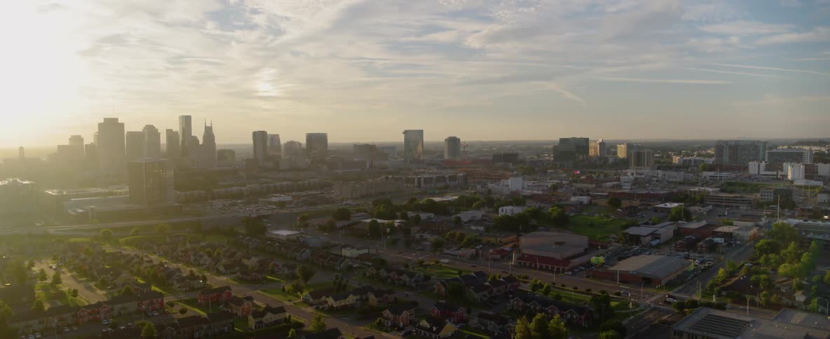 The sun sets behind skyscrapers