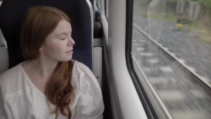 Woman sitting on a train looks out the window