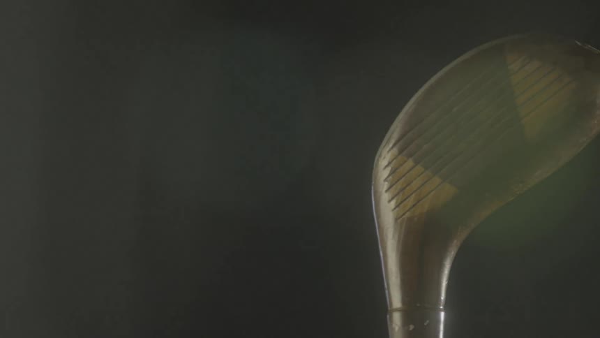 Sunlight is gleaming off of a golf driver as it rotates