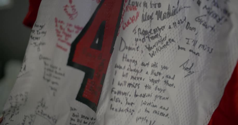 A person is examining a jersey with writing on it