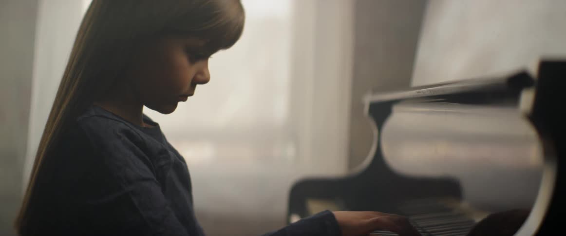 A child is playing the piano in the dark room