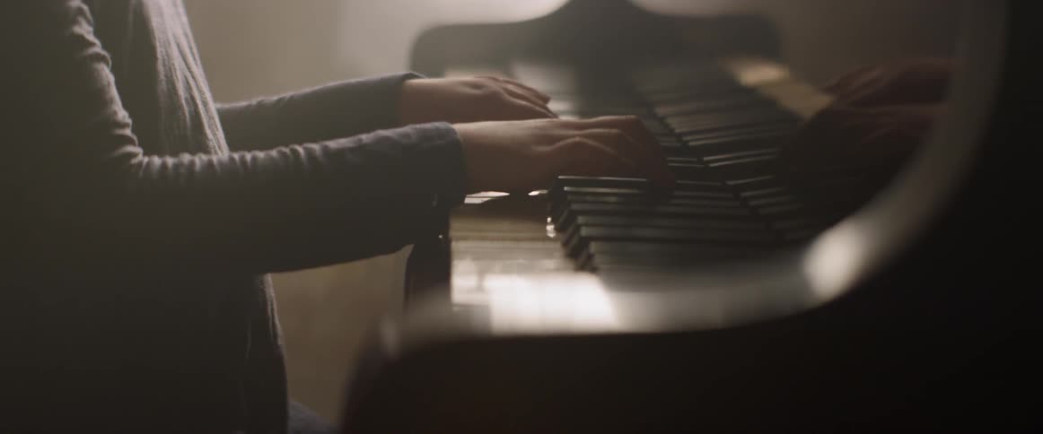 Girl plays piano in a sunny room