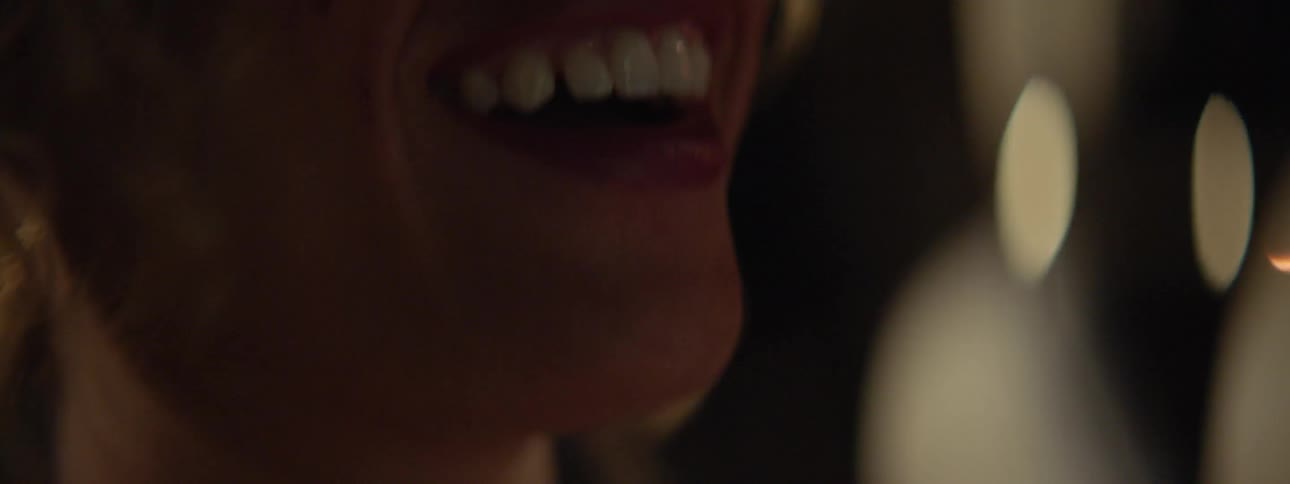 A woman wearing red lipstick laughs