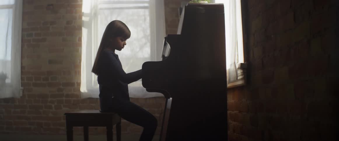 Young girl plays a piano