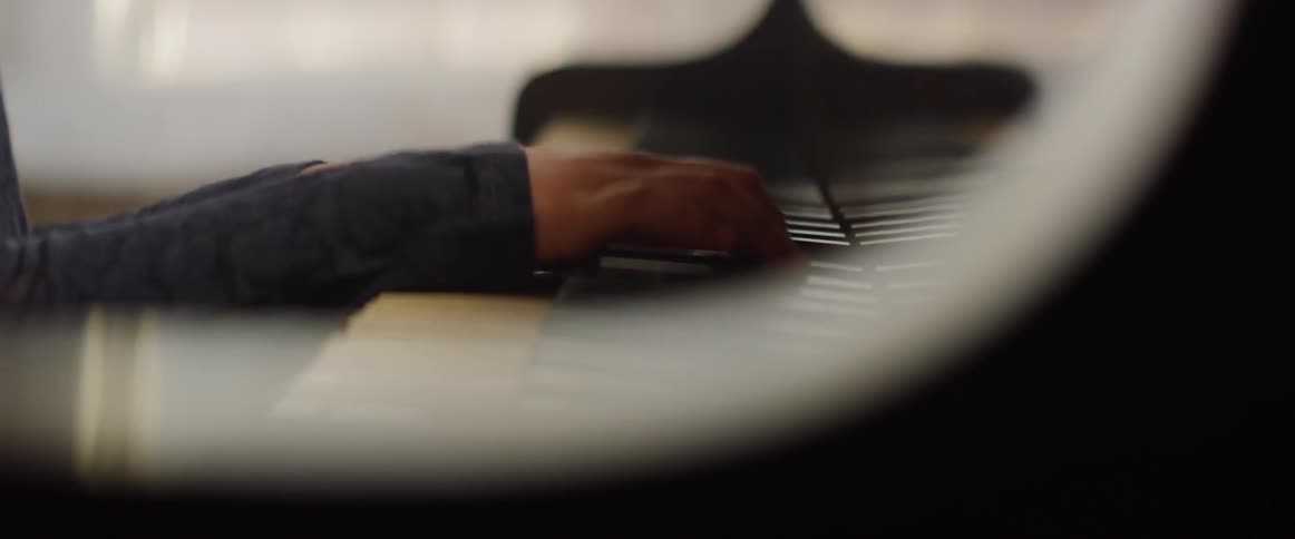 A child's hands play the piano