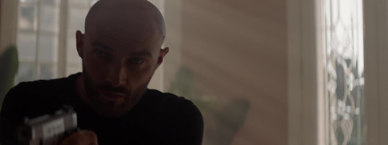 Man walks through a house while holding a gun
