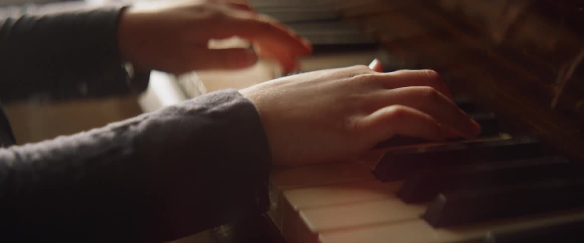 A girl plays a piano