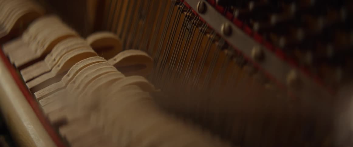 The piano is being used and the strings are moving