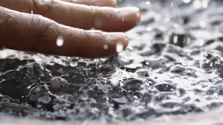 Someone is holding their hand above a vibrating pool of water