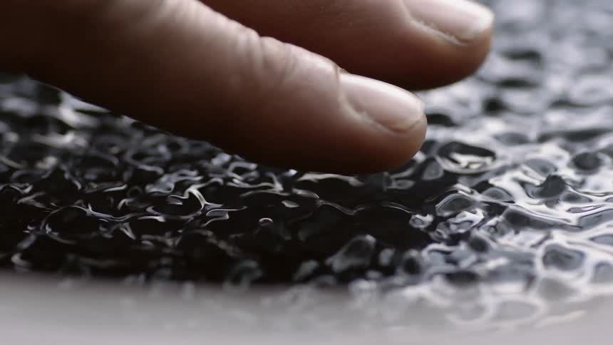 A man holds his hand over vibrating water
