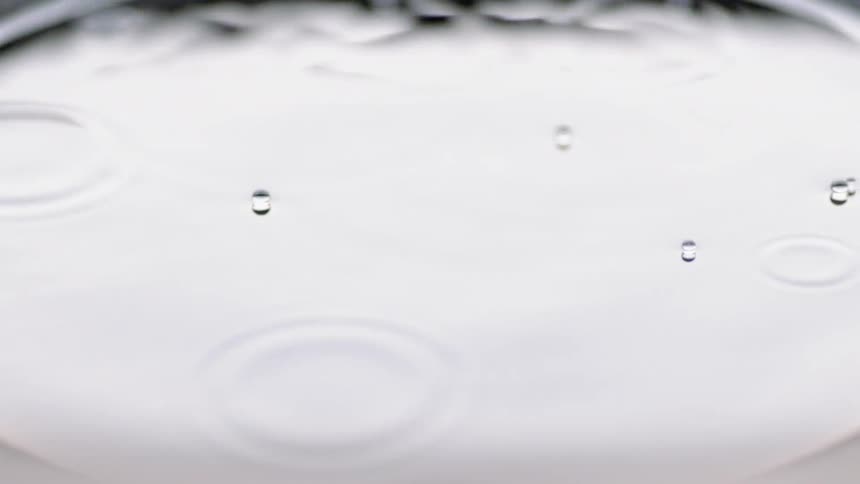 Liquid bubbles popping while floating on top of liquid