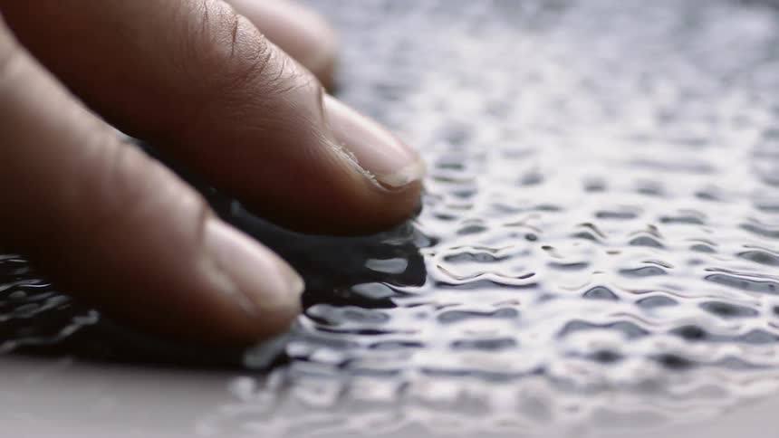 Fingers are resting on top of a liquid that is vibrating