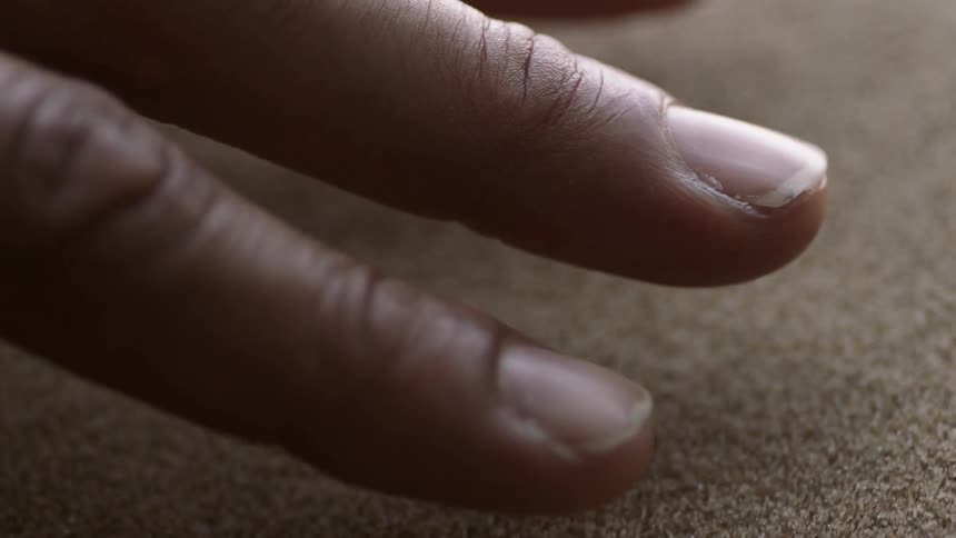 Sand particles vibrate beneath fingers