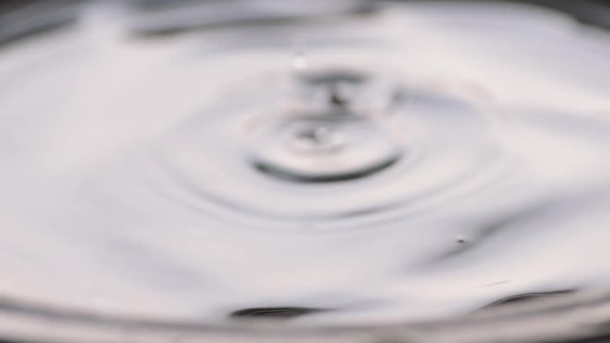 Water droplets fall and ripple as a man lifts his hand up