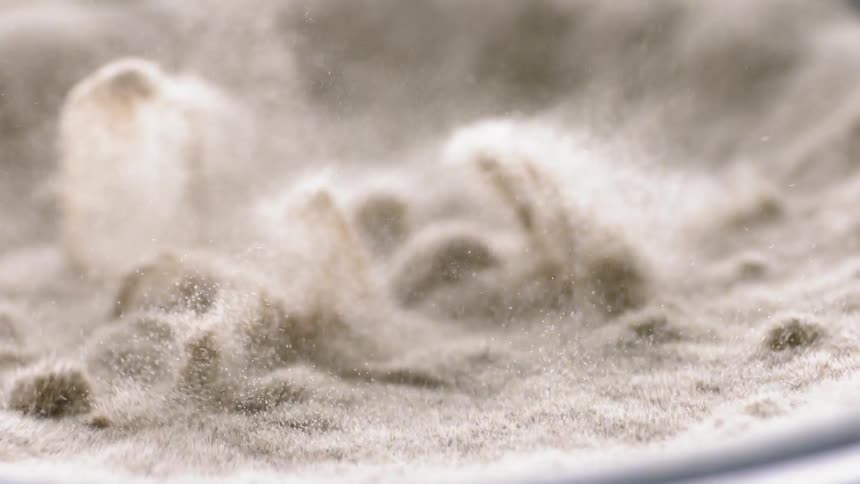 Sand is vibrating and jumping in a container in abstract