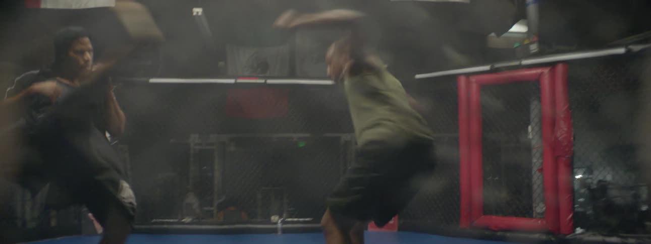 Two men train in an mma ring