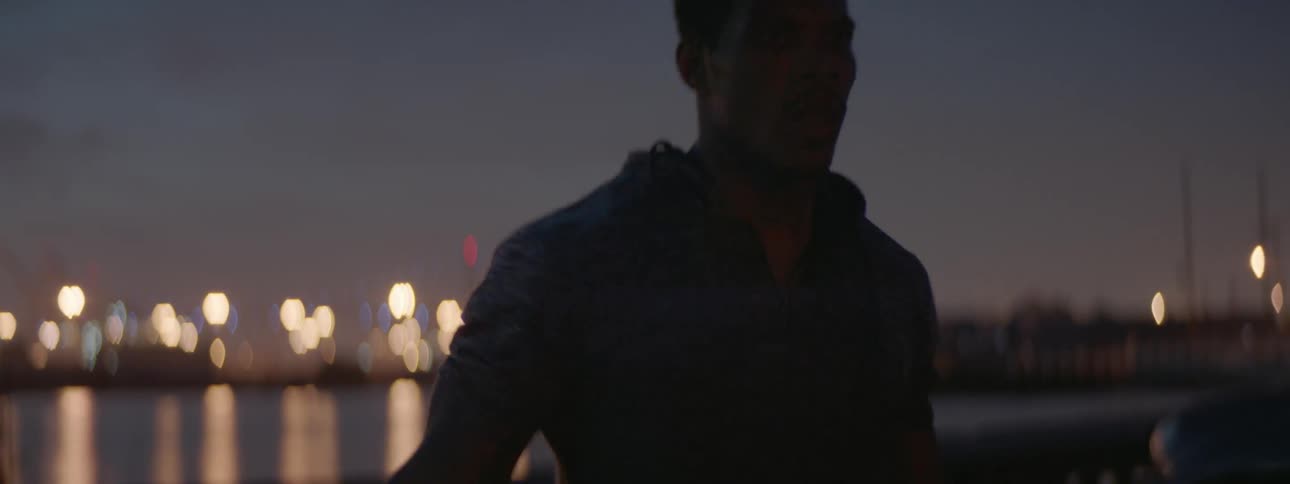 A man uses a jump rope in a city at dusk